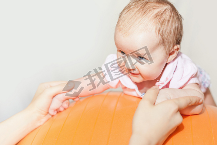 Mom with happy baby doing exercises at gymnastic ball