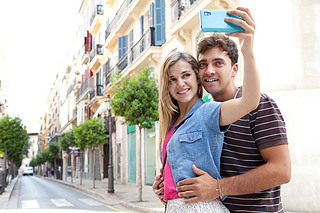 couple taking pictures and selfies using a artphone