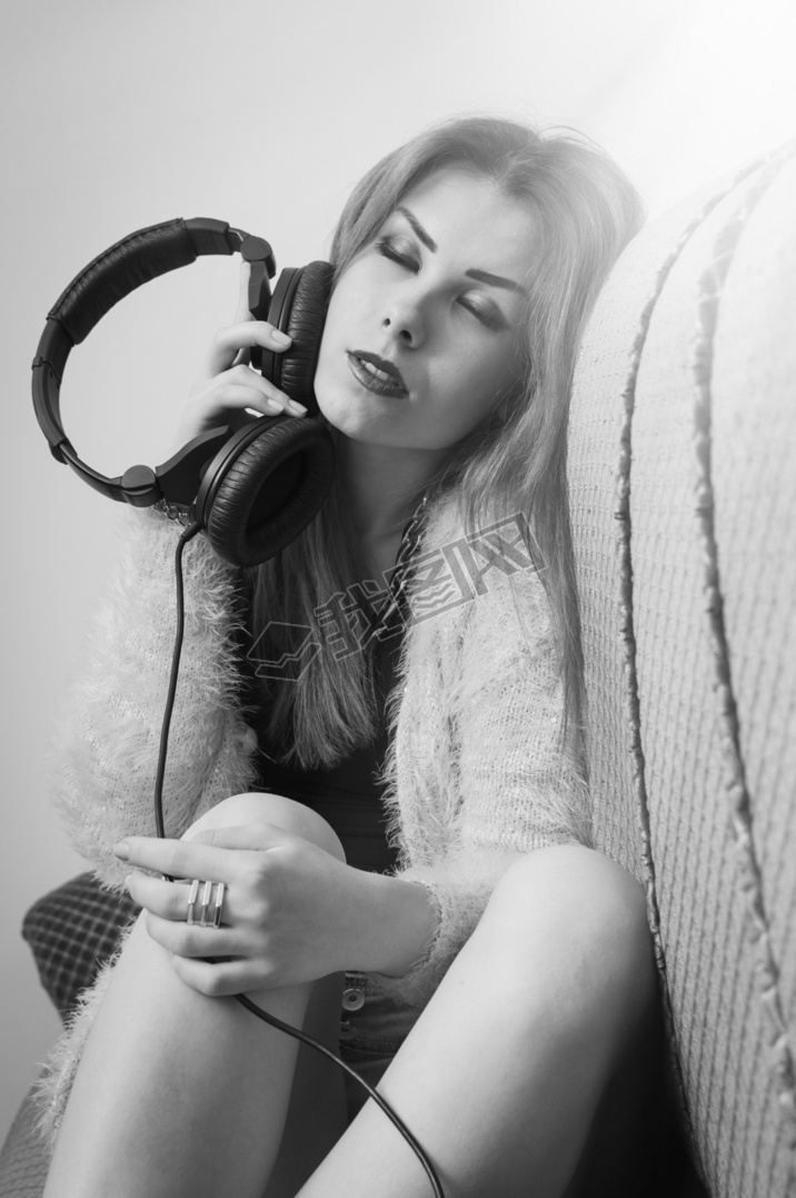 Picture of sexy pretty young lady hing fun enjoying music from headphones. Black and white photogr