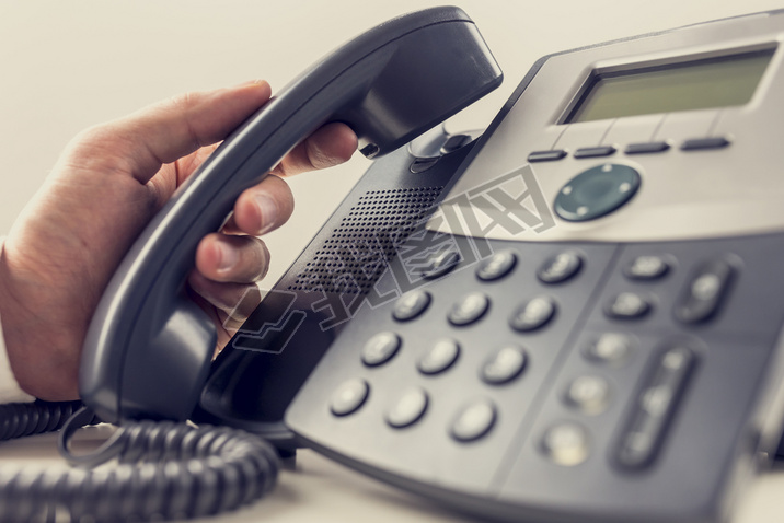 Closeup of male operator about to answer a phone call