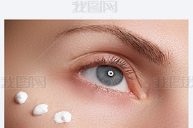 Portrait of young woman with fresh clean face with points of moisturizing  cream under the eye