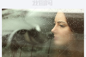 Sad woman looking through a car window