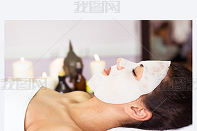 Prettyl woman with facial mask at beauty salon. Spa treatment