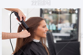 Experienced young hairstylist is serving her customer