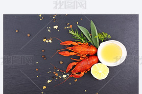 Delicious fresh lobster on dark vintage background. Seafood with aromatic herbs, spices and vegetabl