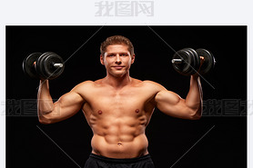 Smiling satisfied sportan with dumbbells in hands, isolated on black