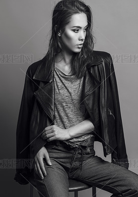 Portrait of a fashionable model with natural make up and perfect skin, dressed in men's jeans, grey 