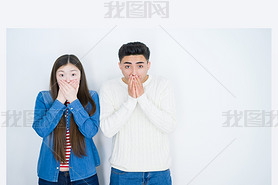 Beautiful young asian couple over white isolated background shocked covering mouth with hands for mi
