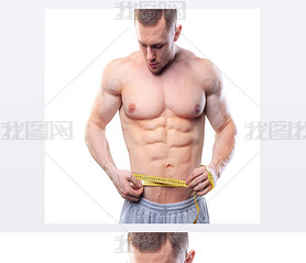 Image of muscular man measure his waist with measuring tape in centimeters. Shot isolated on white b