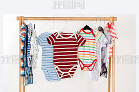 Dressing closet with clothes arranged on hangers.Colorful onesie of newborn,kids, toddlers, babies o