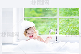 Baby girl taking bath with foam