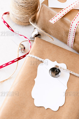 Wrapped gifts decorated with silver bells and gift tags 