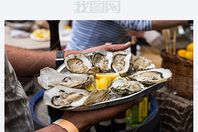 Server with Tray of Fresh Oysters with Lemon