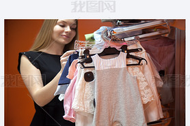 Young mother choosing baby clothes