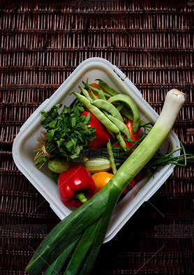 There are vegetables on a dark rattan table