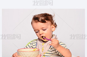 Baby eating food with a spoon, toddler eating messy and getting