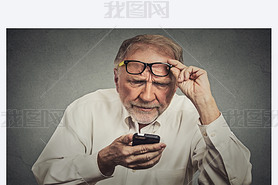 elderly man with glasses hing trouble seeing cell phone