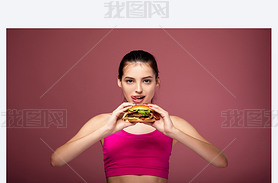 Athletic white girl with a beautiful body eats a burger.