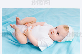 baby in hat lying on a blue blanket