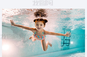 adorable kid swimming underwater in blue water in swimming pool 