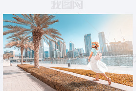 Happy asian girl walking on a promenade in Dubai Marina district. Trel and lifestyle in United Ara