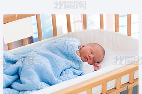 Newborn baby boy in hospital cot