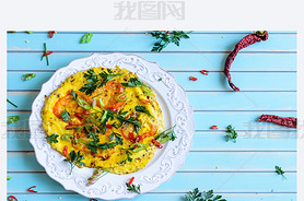 Omelette with tomatoes, chili on plate over wooden turquoise background
