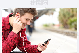 Man listening to the music waiting in a train station