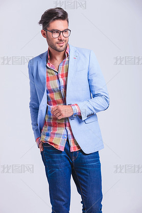 fashionable man walking in studio with hand in back pocket 