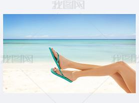 Slim female legs on sandy beach