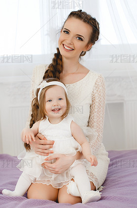 Happy family,mother playing with her baby in the bedroom.