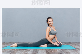 Young iling girl in sportswear sitting on splits