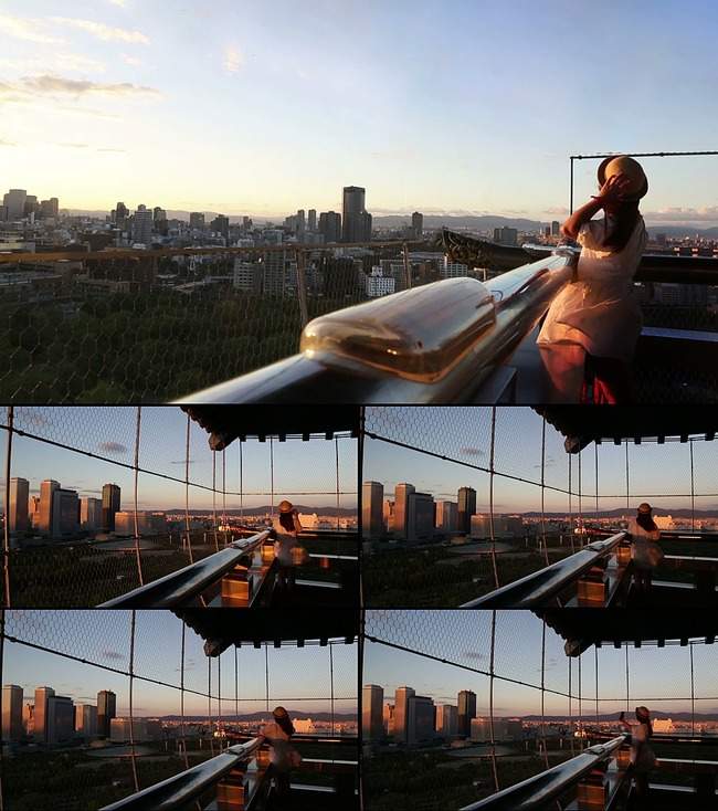 女孩站在楼顶天台看城市美景实拍视频素材