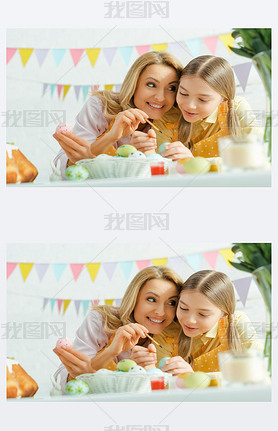 selective focus of cheerful daughter and mother painting easter eggs at home