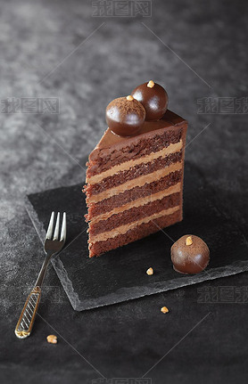 Slice of Contemporary Chocolate Truffle Layer Cake with chocolate udge, decorated with handmade ch