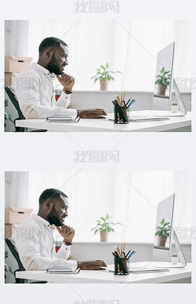 side view of cheerful handsome african american businesan working at computer in office