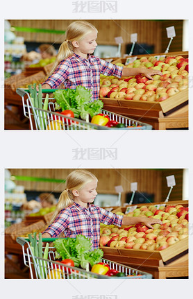 Cute little customer choosing the most tasty apple from assortment