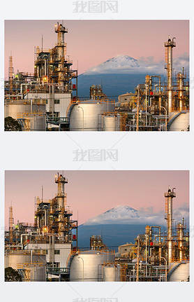 Mt. Fuji, Japan as viewed from behind factories at dusk.