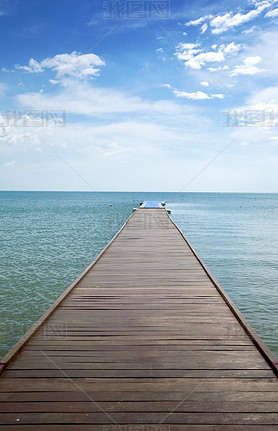 Wooden boardwalk above water out towards open ocean