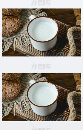 cup of warm milk and bread on a wooden background