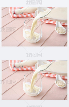 Pouring of rice milk from jug into glass on table