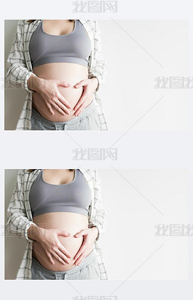 Pregnant woman making heart sign on belly. Woman holding her hands in a heart shape on her pregnant 