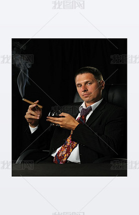 The man with a cigar and a glass of cognac