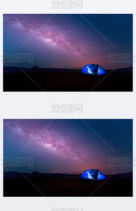 Camping. Blue tent glows under a night sky with milky way.