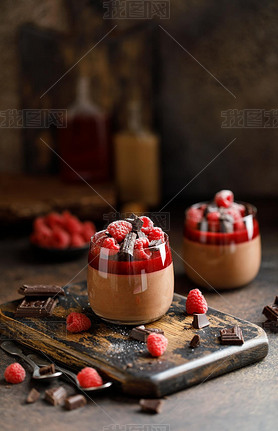 Chocolate panna cotta with raspberry jelly, raspberries and chocolate pieces 