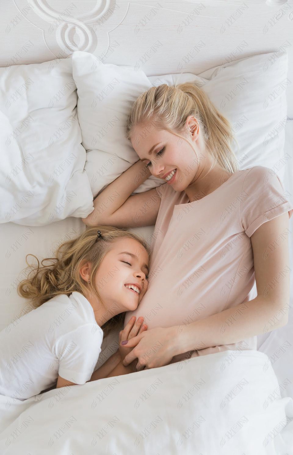 微笑的女儿的顶面看法怀孕的母亲肚腩