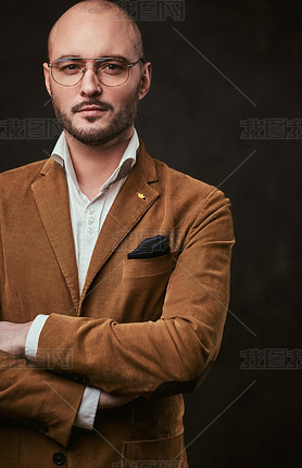 Successfull bald businesan posing in a studio wearing stylish velvet jacket, white shirt and glass