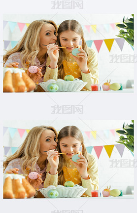 selective focus of mother iling near cheerful daughter painting easter egg 