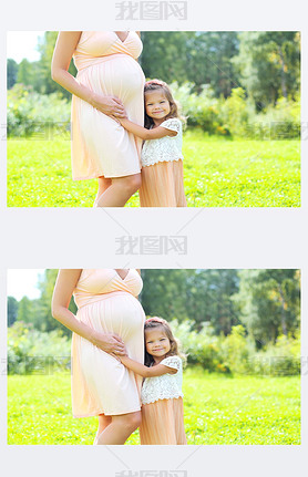 Happy pregnant woman, cute little child daughter hugging mother