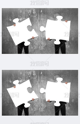 Two business people assembling white jigsaw puzzles with concret